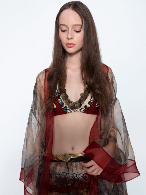 The Koi Hand Embroidered Chain Bikini worn with a sheer red cape, close up