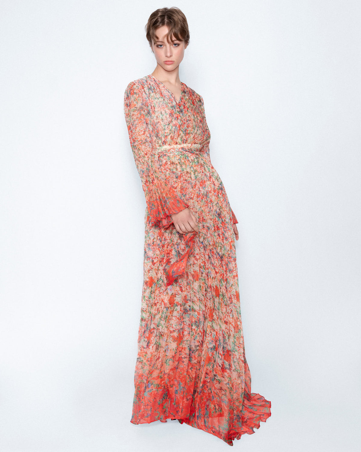 The Coral Pleated Maxi Dress worn by a model, full length