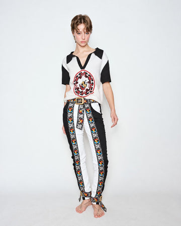 The Embroidered Cascade Jeans worn with a black and white knit polo, full length