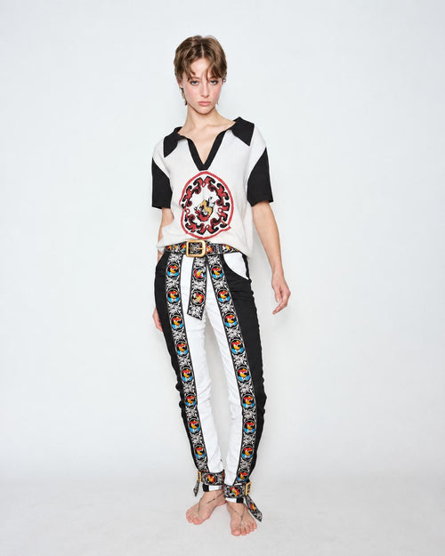 The Embroidered Cascade Jeans worn with a black and white knit polo, full length