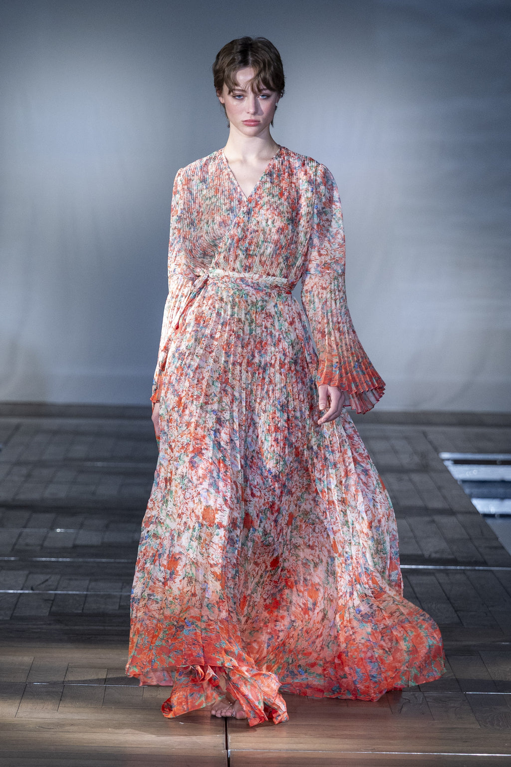 The Coral Pleated Maxi Dress worn on the runway