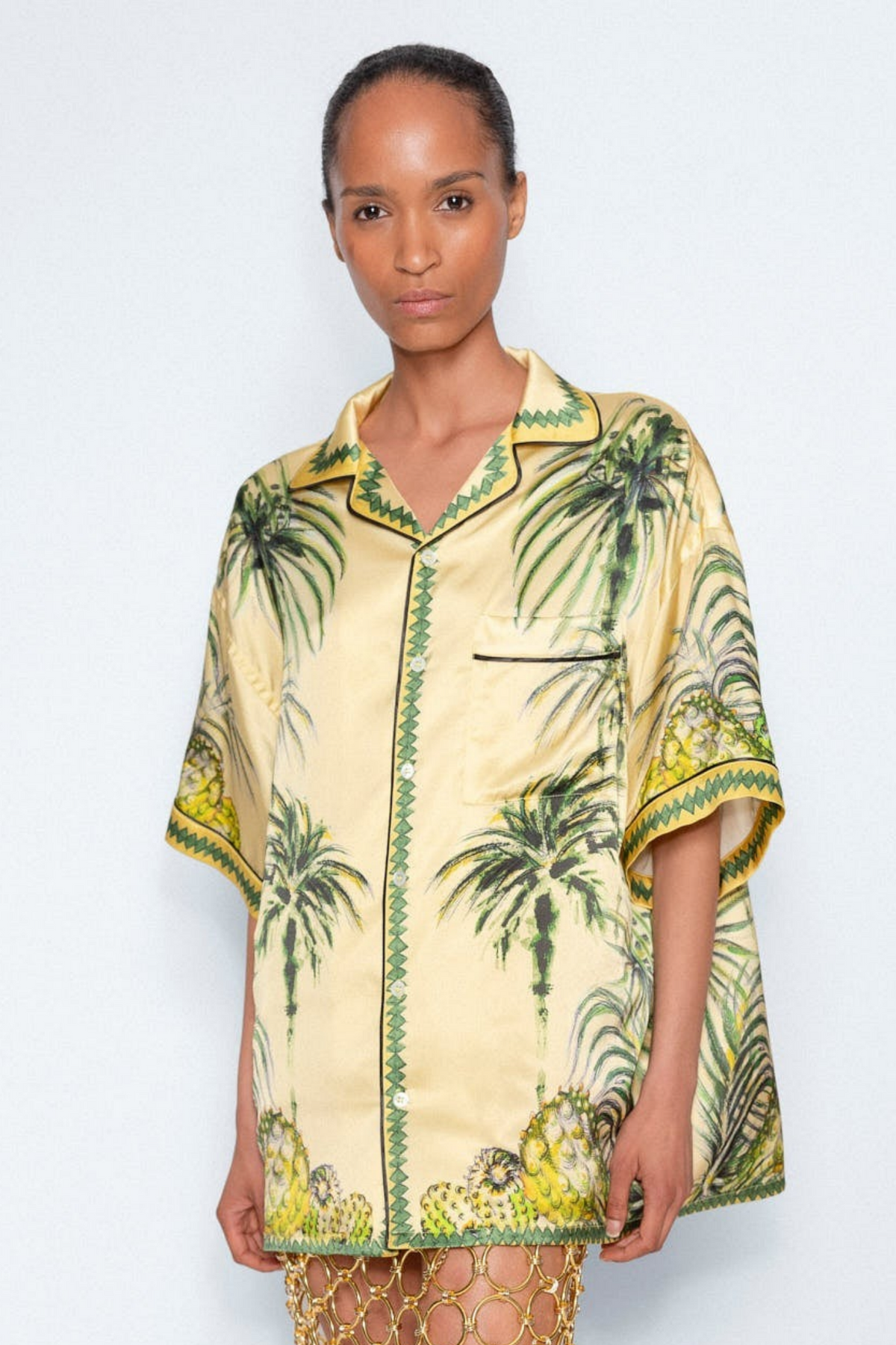 Yellow Palm Print Shirt worn with a gold chain skirt, full length